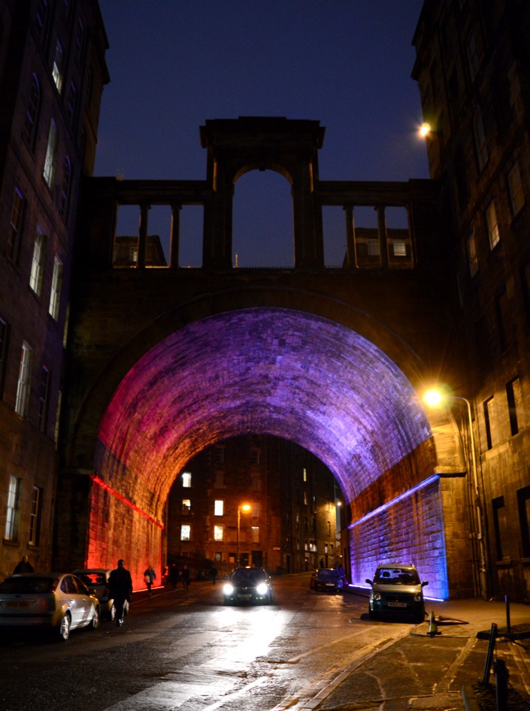 Voiture de nuit passant sous un tunnel ayant un éclairage rose/rouge/violet