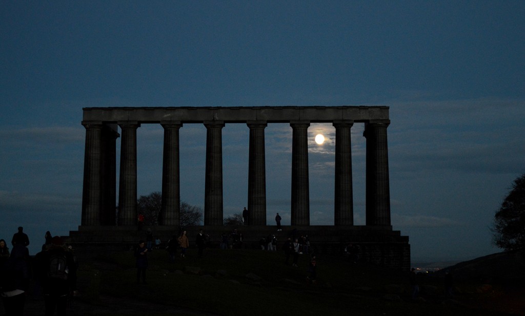 La pleine lune passant au milieu de l'avant dernière colonne du Monument National d'Écosse