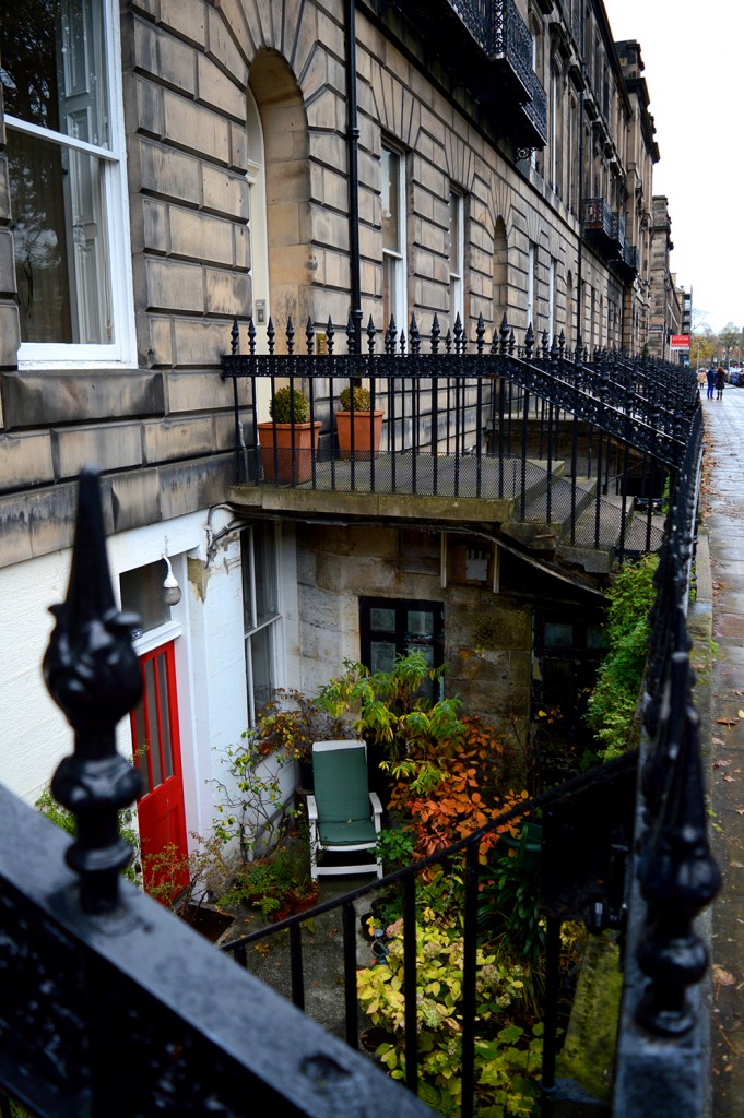 Mini rue en contrebas d'un immeuble, au niveau -1, avec terrasse emménagée : fauteuil, plantes...