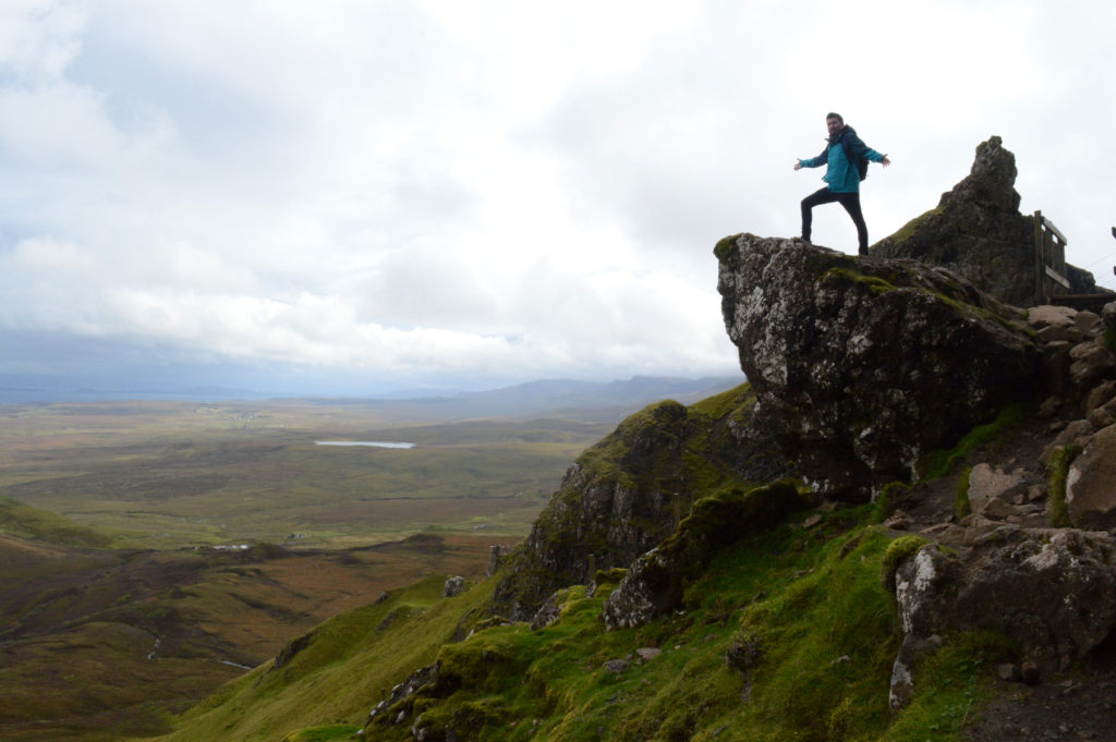 Manu sur un rocher avec vue sur les alentours de Quiraing