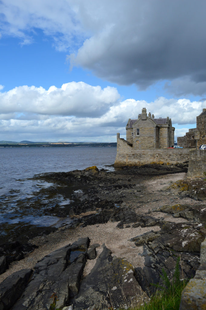 Marée basse, rochers noirs, et chateau Fort Williams au loin