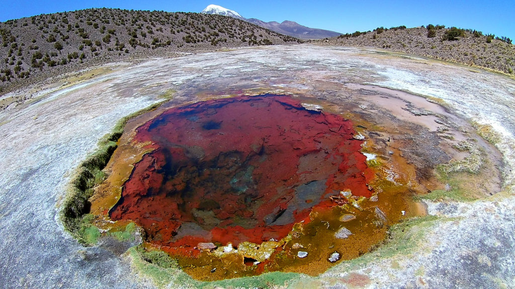 Gros plan d'un geyser, de couleur rouge, orange et verte
