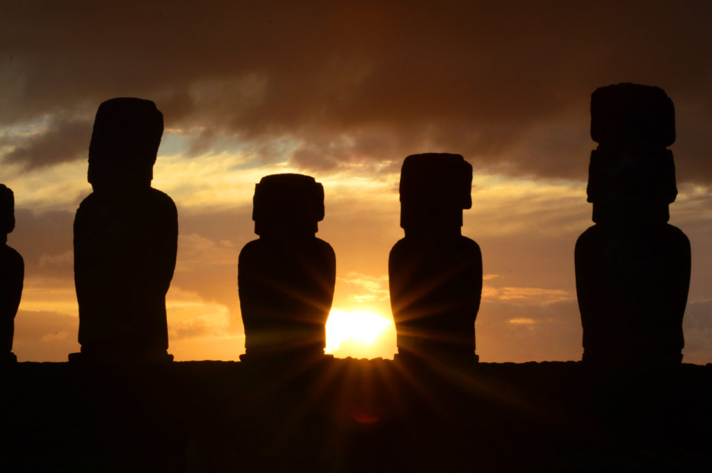 Statues en contre jour, paraissant toutes noires, avec le soleil se levant entre deux d'entre elles