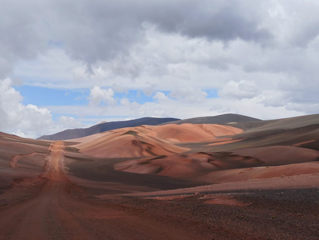 Route au milieu de montagnes ocres et grises