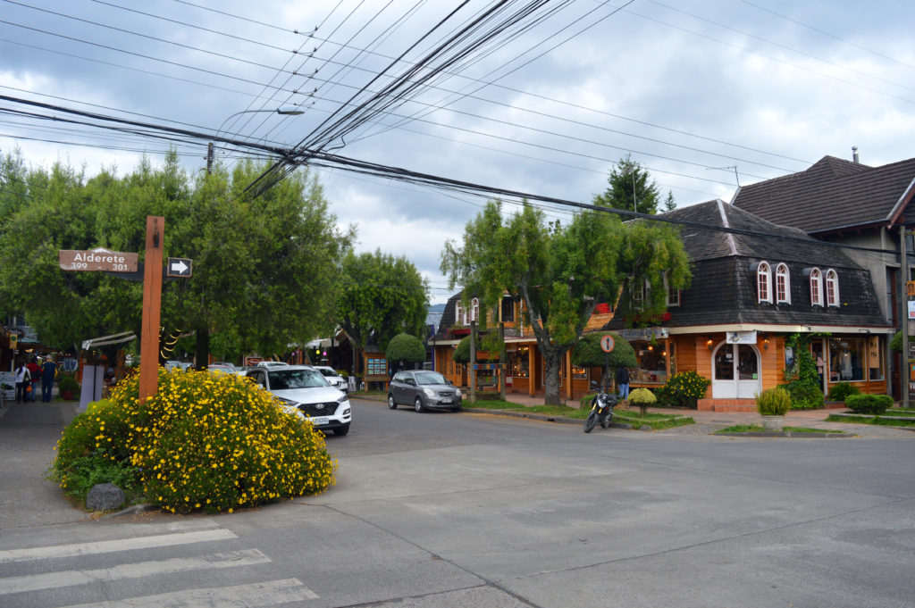 Intersection de 2 routes à Pucon, avec des maisons en bois et aux tuiles grises