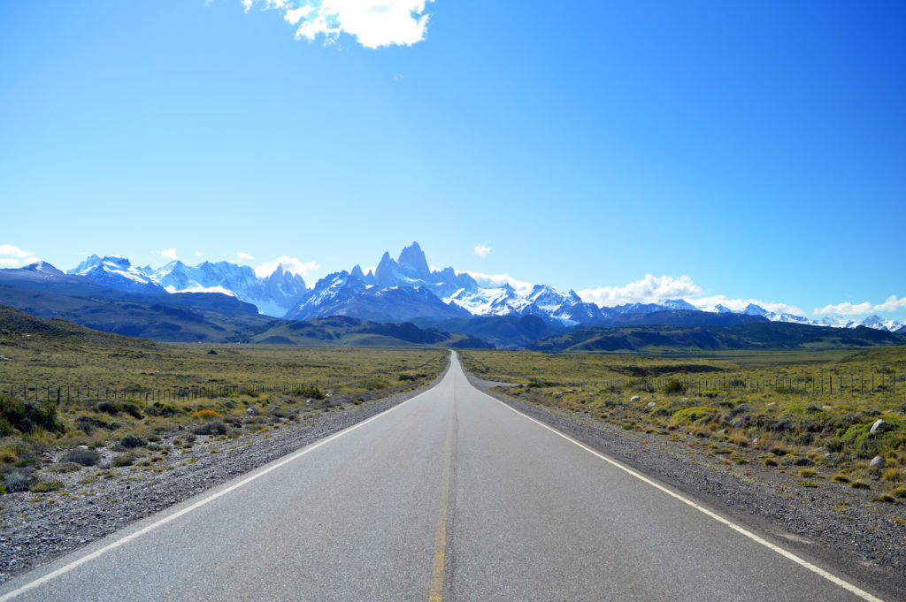 Route au premier plan semblant aller droit sur la cordillère des Andes au fond