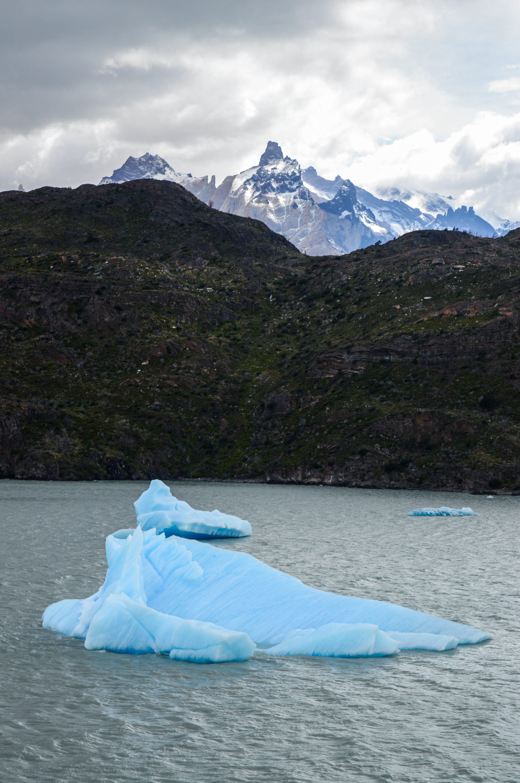 iceberg bleu dans le lac et montagnes