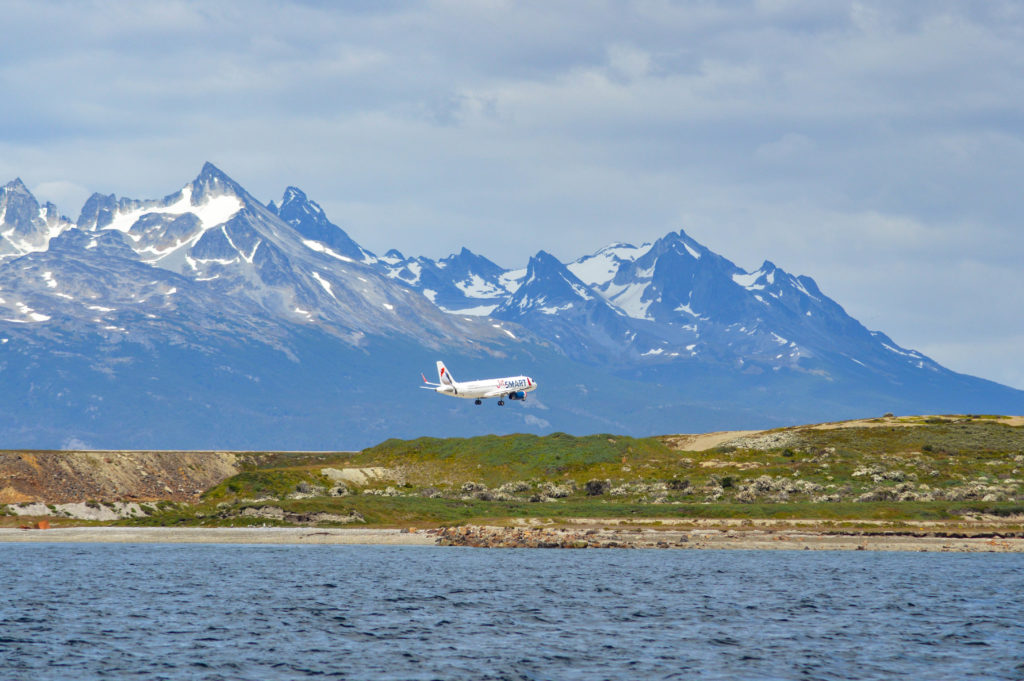 atterissage d'un avion à l'aéroport d'Ushuaia, avec les montagnes en arrière plan