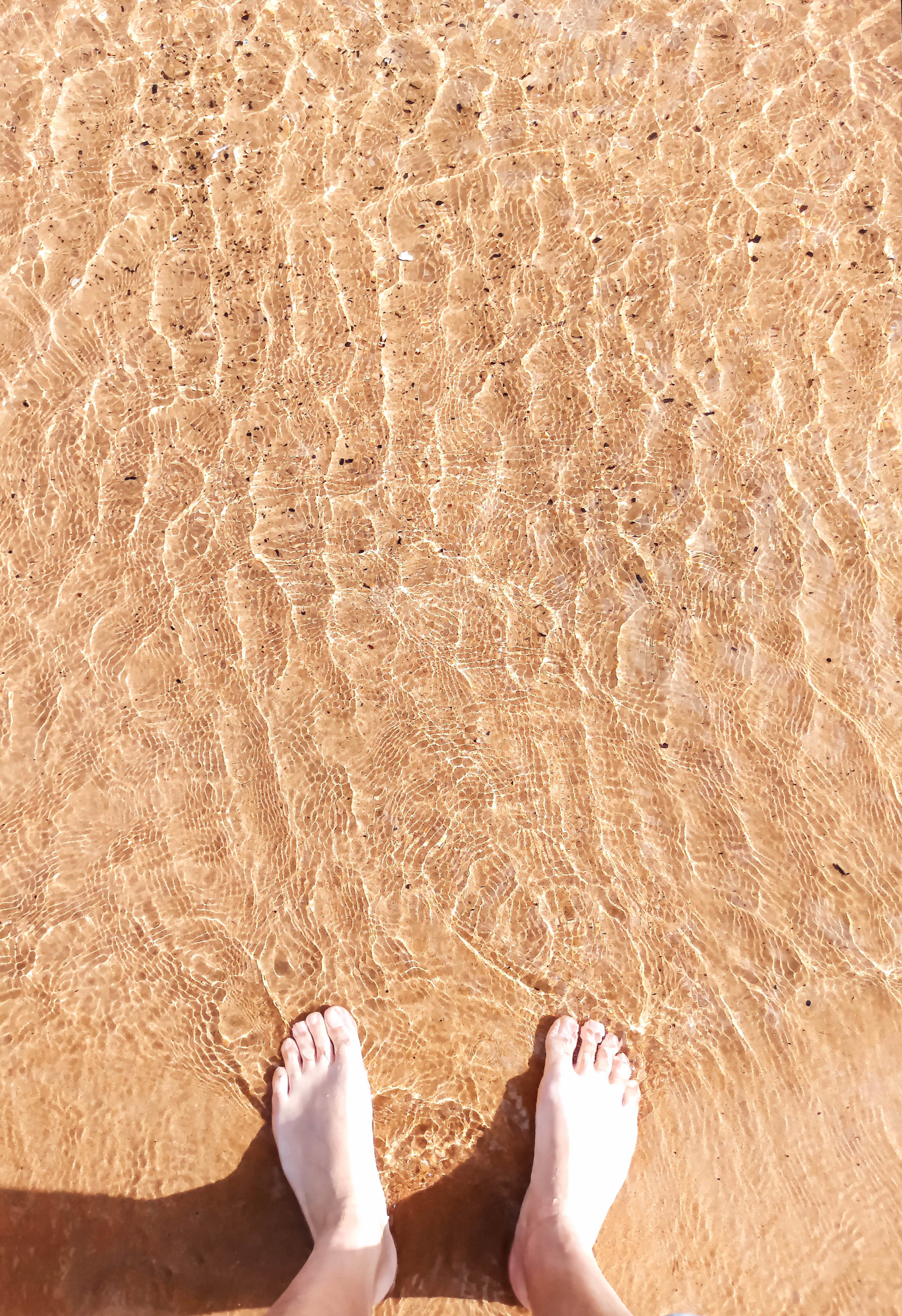 les pieds dans l'eau sur le sable doré