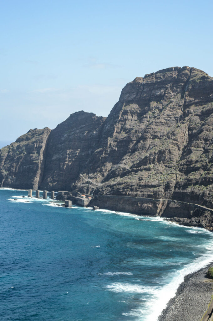 Falaises rocheuses noires, tombant à pic dans la mer bleu azur