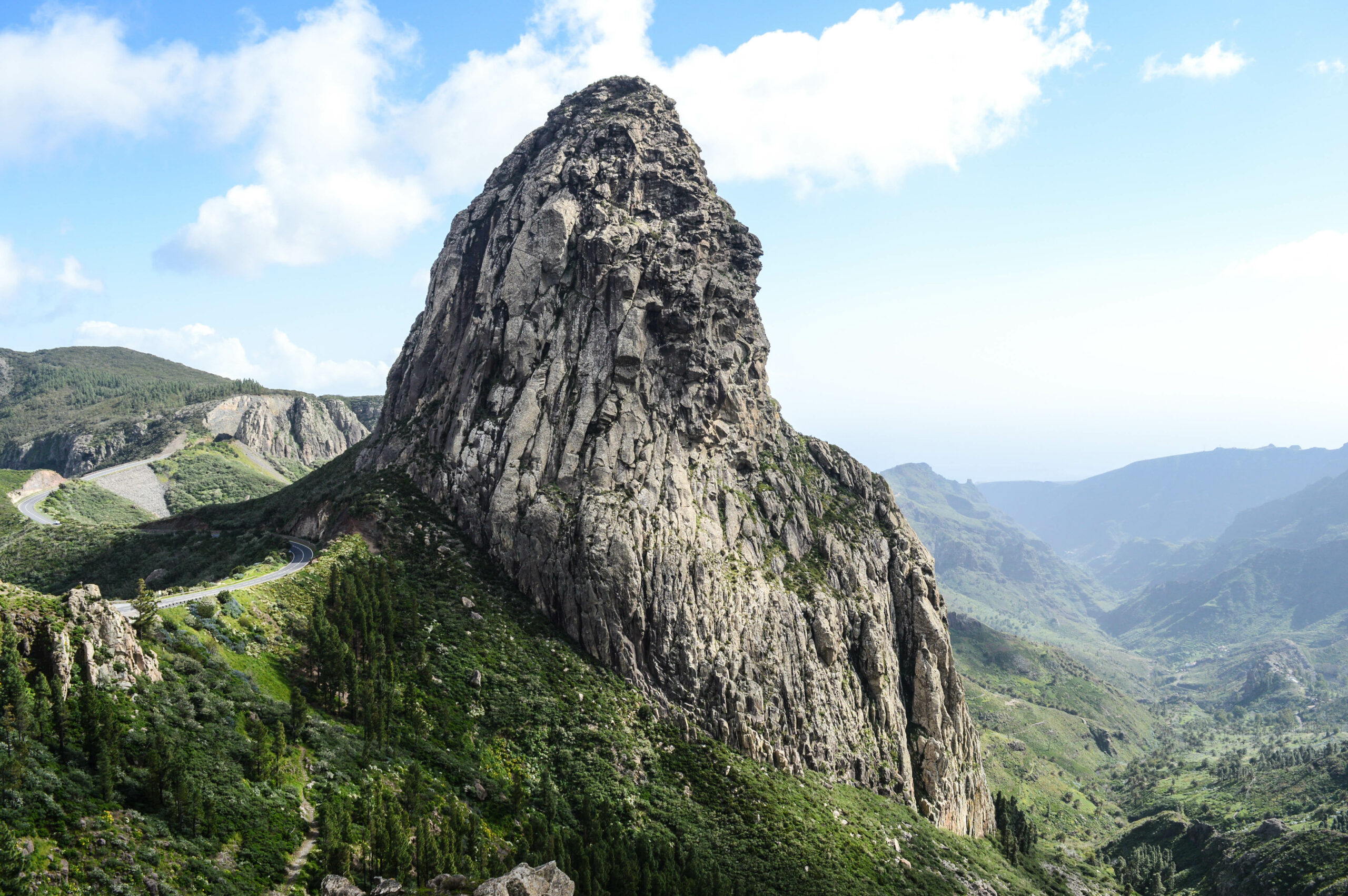 Rocher d'Aganda, immense, à la forme conique, avec la route qui parait minuscule à ses pieds à gauche. A droite la vallée du parc Garajonay