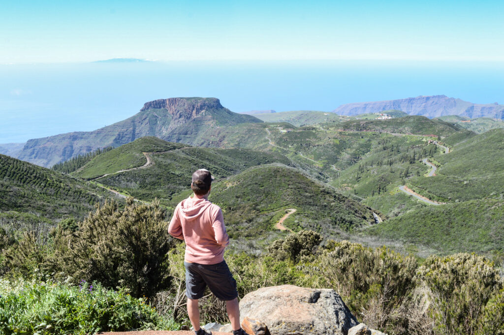 Manu de dos, observant la vue sur la Gomera, avec la Fortaleza au loin, et l'île de El Hierro tout au loin sur l'océan
