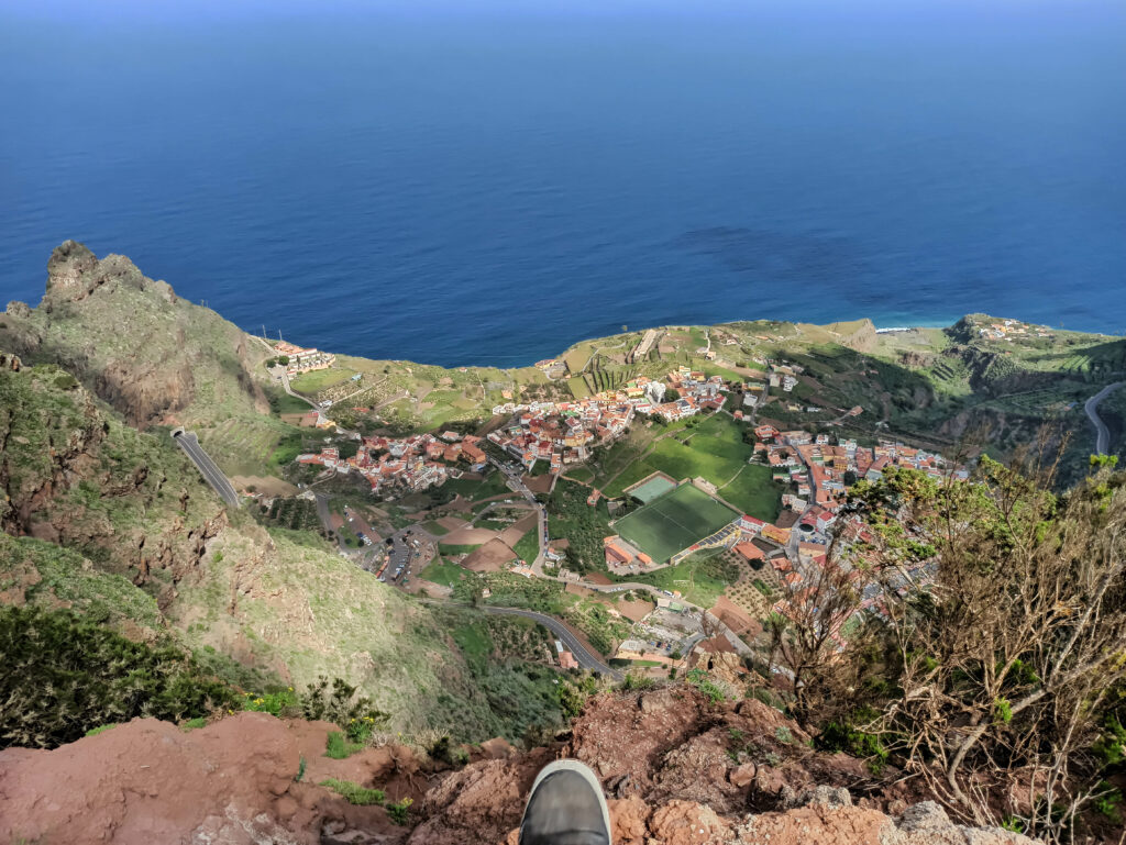 Vue à pic, avec un pied en bord de falaise, sur le village d'Agulo et la mer en contrebas, depuis le mirador de Abrante