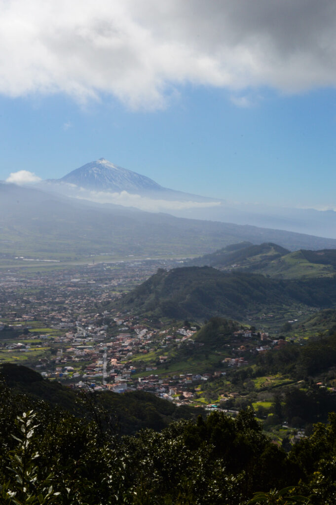 Montagnes vertes du parc Anaga avec au milieu des maisons dans la vallée, et le volcan de Tenerife, le Teide, en arrière plan