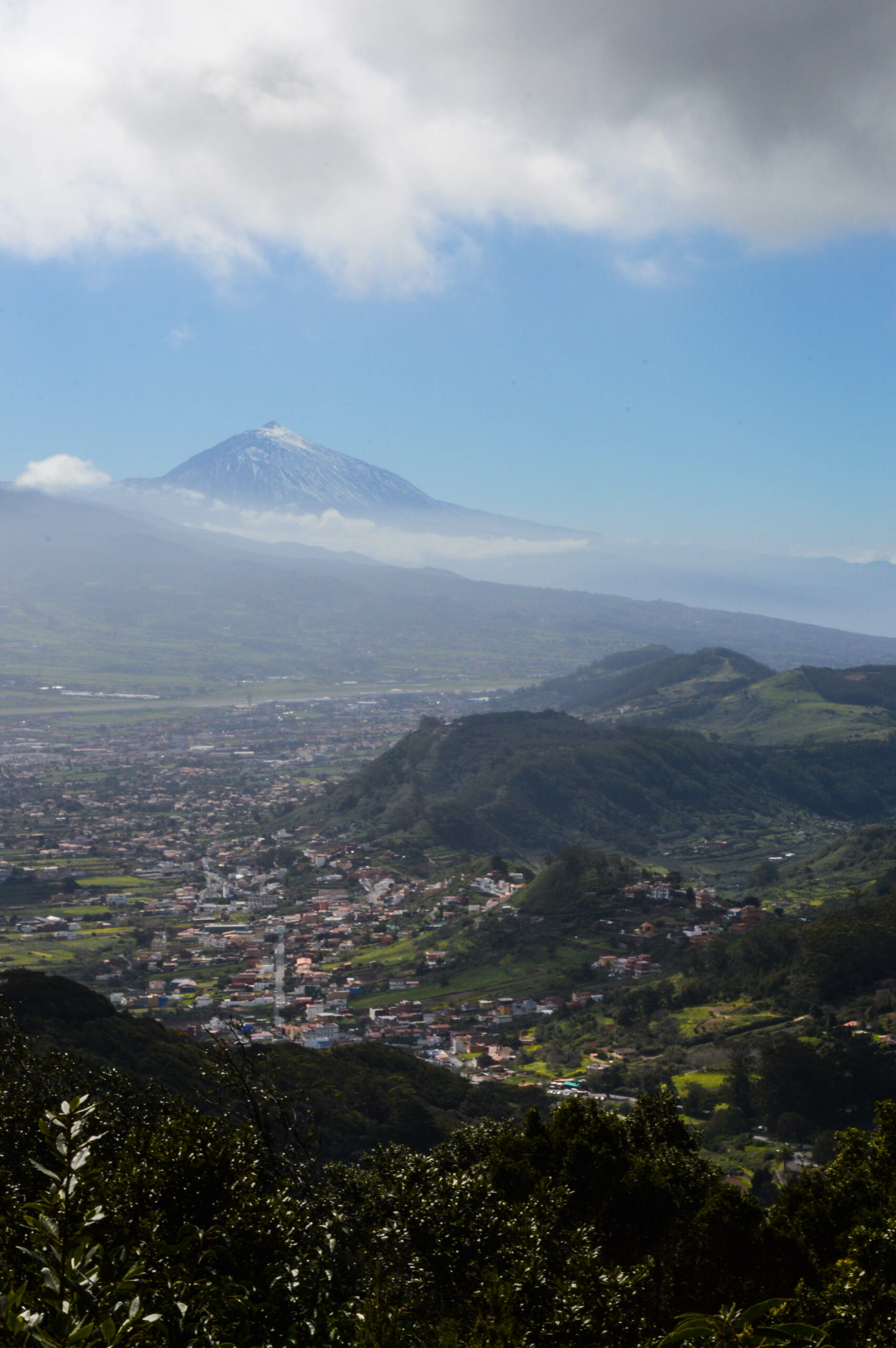 Montagnes vertes du parc Anaga, avec au milieu des maisons dans la vallée, et en arrière plan le volcan de Tenerife, le Teide, 