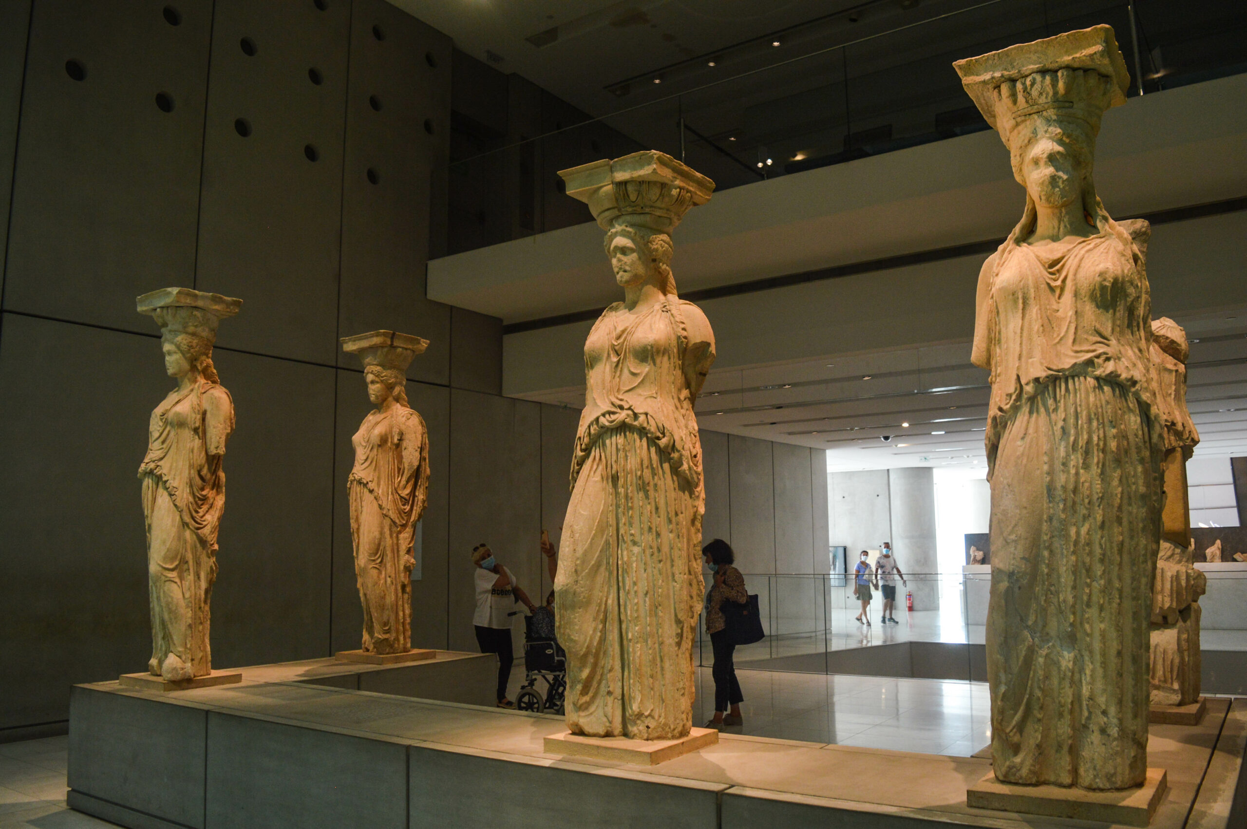 4 statues de femmes cariatides, anciens piliers du temple d'Erechthéion, avec chacune une plateforme sur la tête