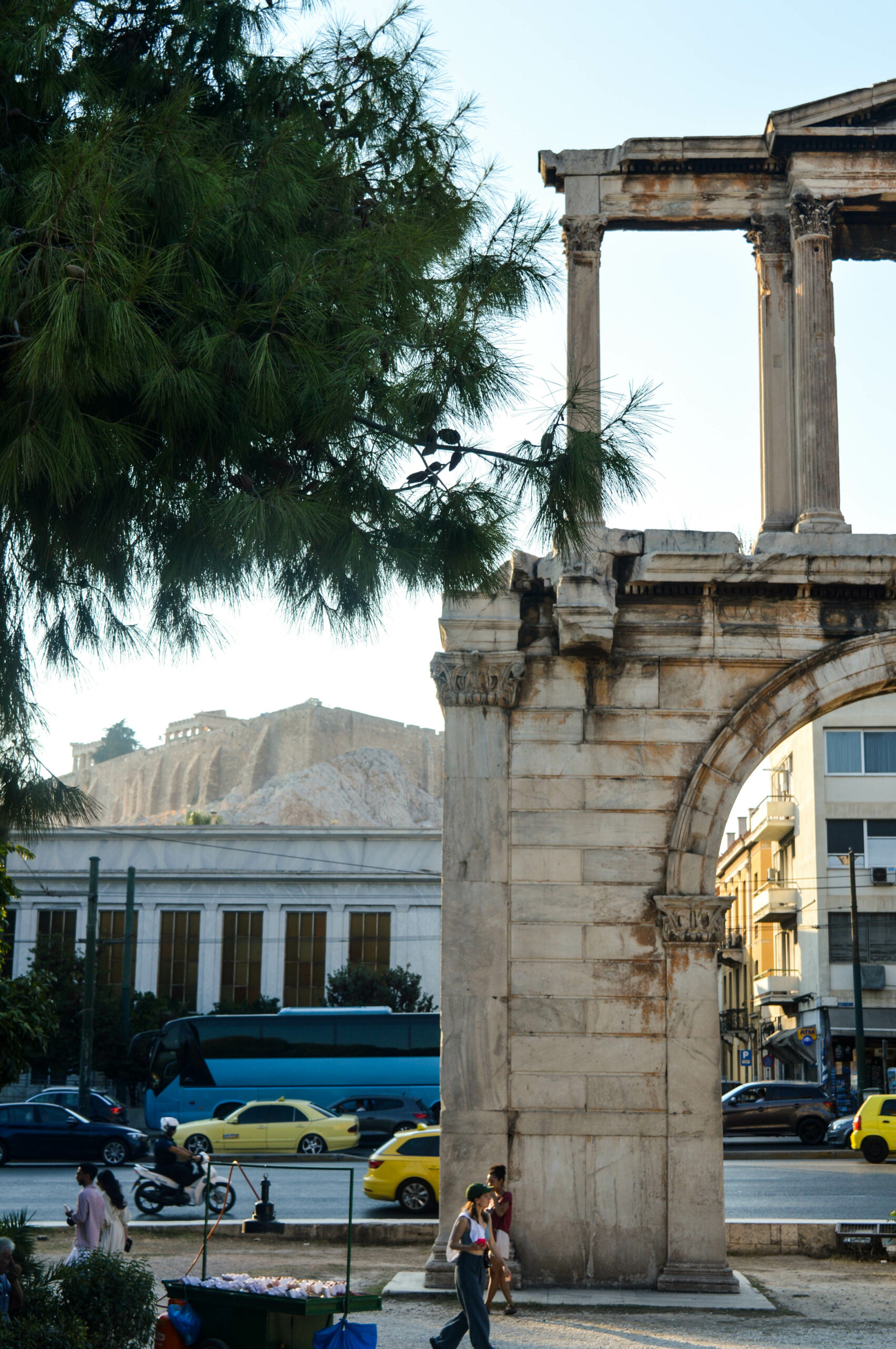 Arbre au premier plan, pilier de la porte d'Hadrien au second plan, et entre les deux l'acropole en arrière plan