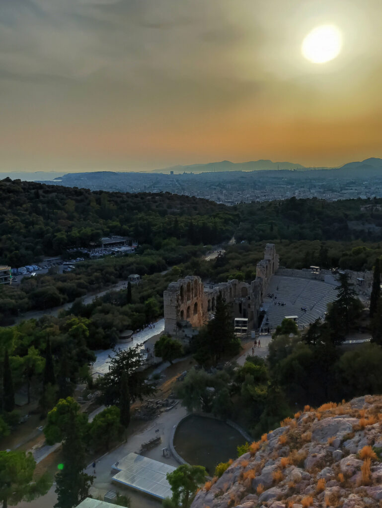 Ciel orangé du soleil couchant, au dessus des ruines du théâtre et de sa forêt