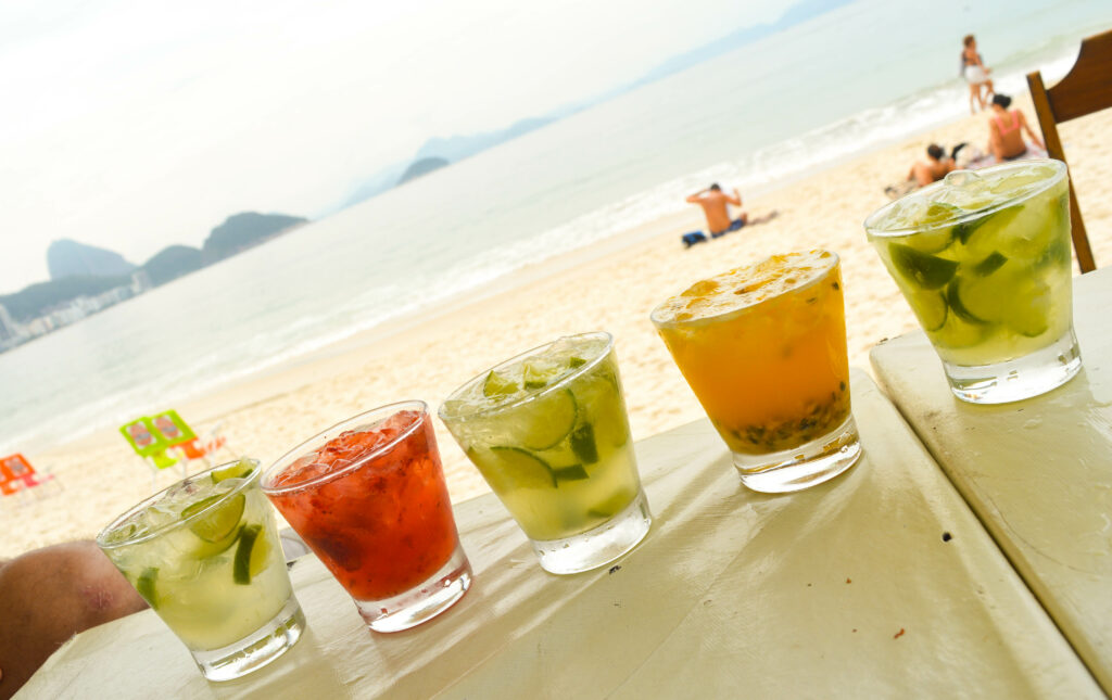 5 verres de différentes recettes de caïpirinhas, sur la plage de Copacabana à Rio