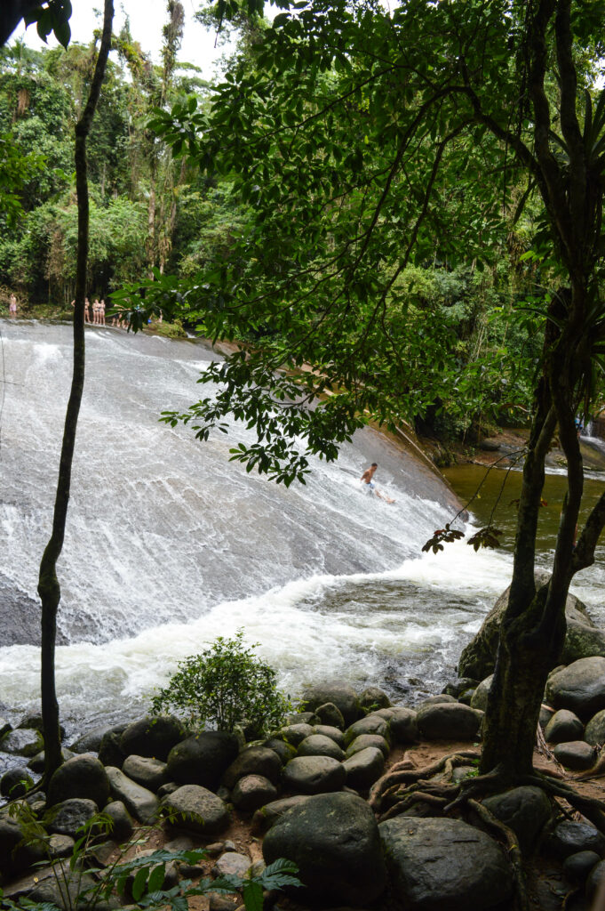 Cascade d'eau de Penha, avec une personne glissant le long de ce toboggan naturel