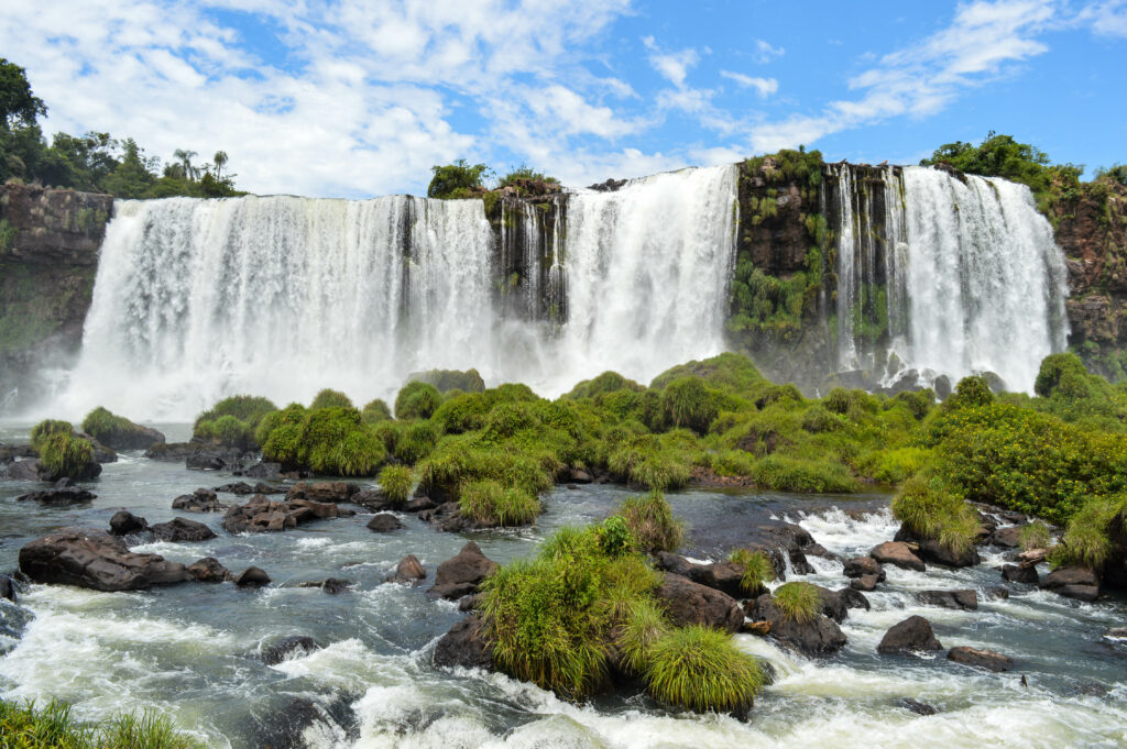 Bassin d'eau au 1er plan, avec des chutes en arrière plan, côté brésil