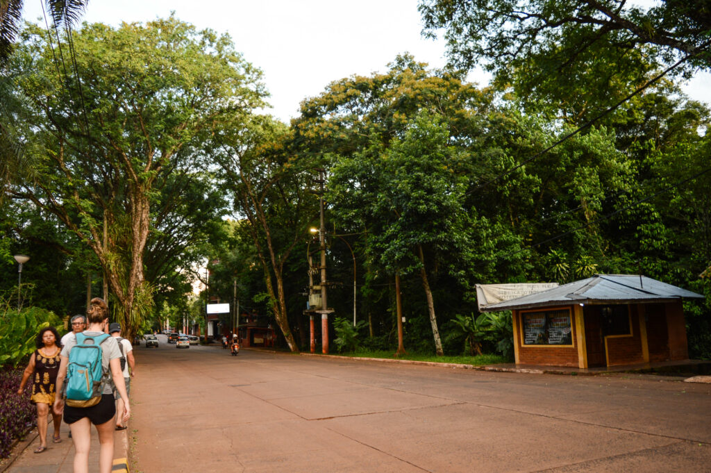 Personnes marchant au bord de la route bordée d'arbres du village d'Iguazu