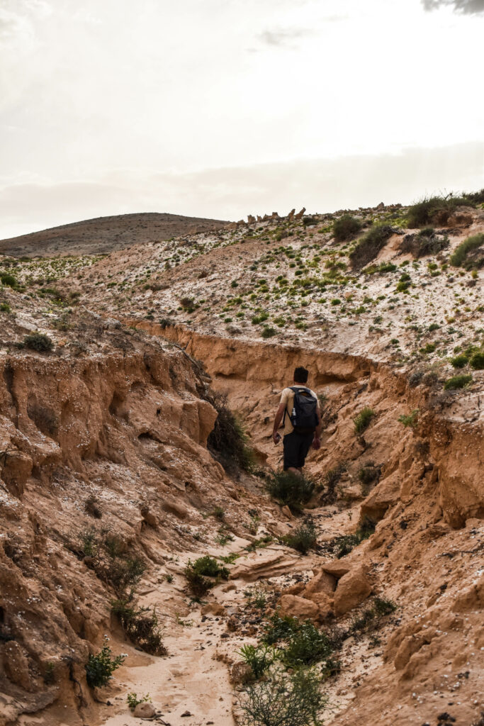 manu au milieu d'un petit canyon pour une randonnée à fuerteventura