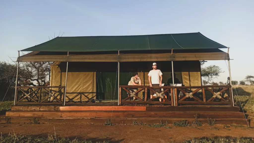 Manu et Thomas sur le porche d'une grande tente luxueuse