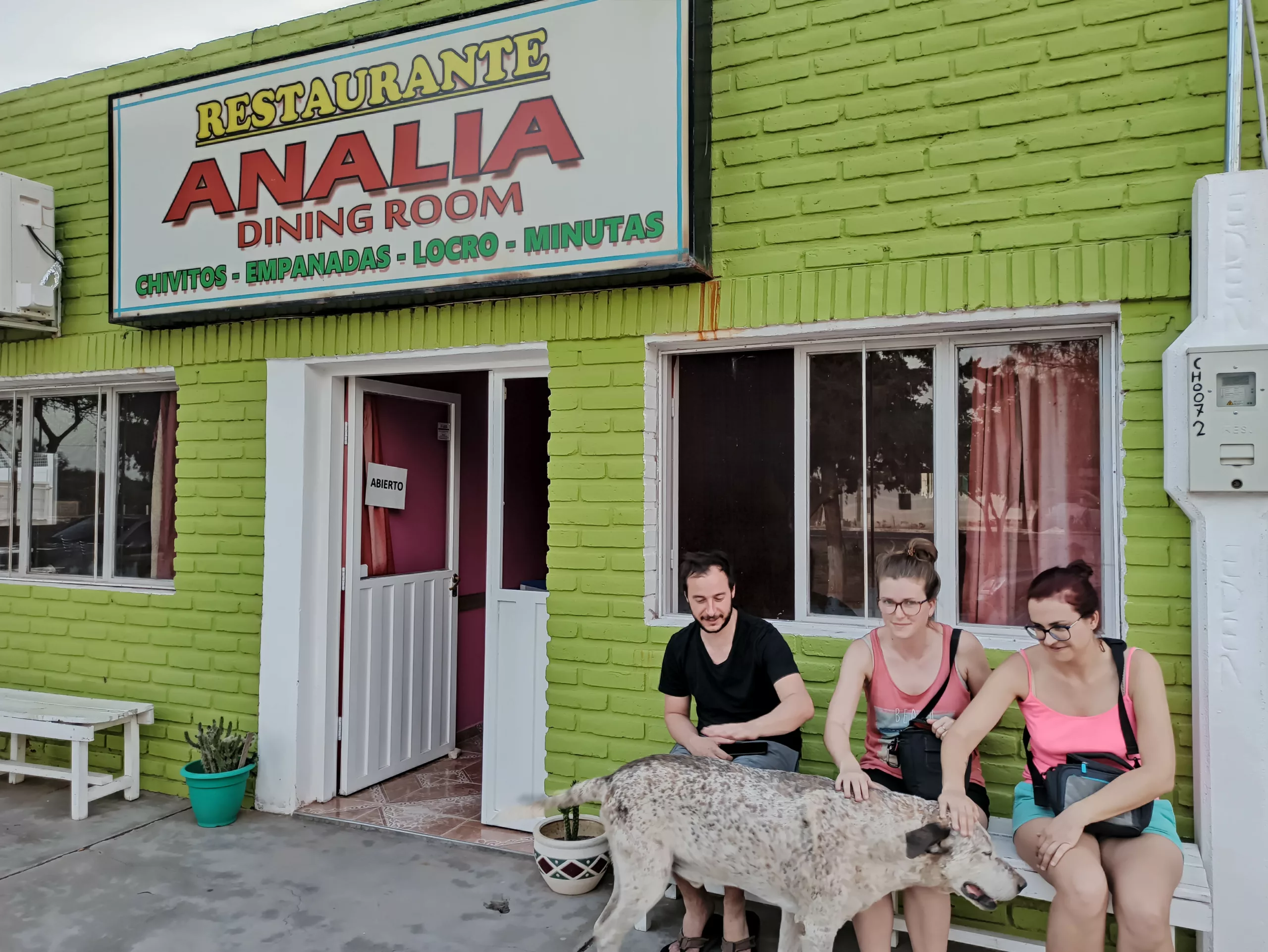 3 personnes et un chien devant restaurant aux briques vertes à Balde de Rosario nord-ouest argentine