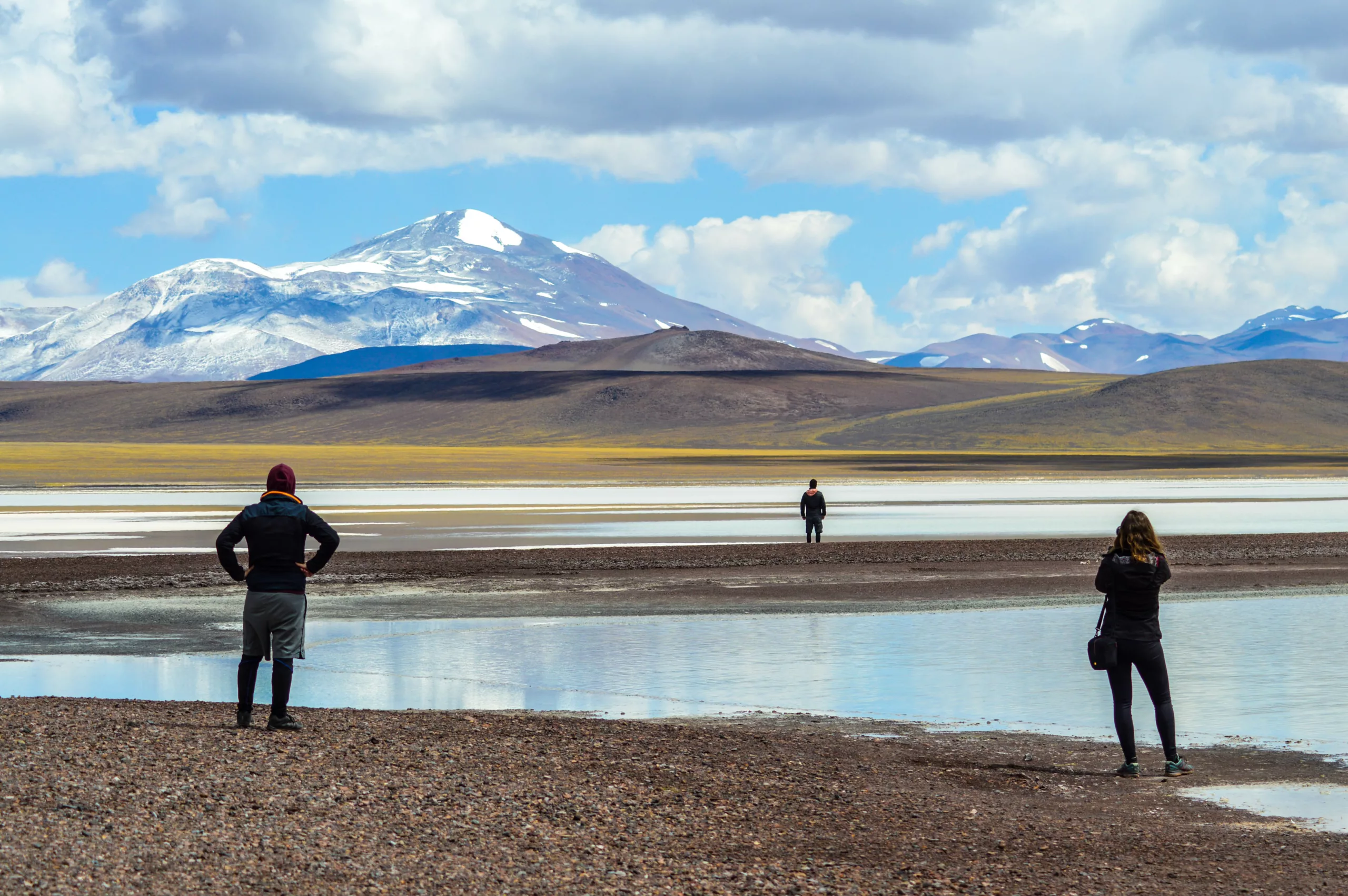3 personnes sur une lagune devant montagne enneigée durant road trip nord-ouest argentine