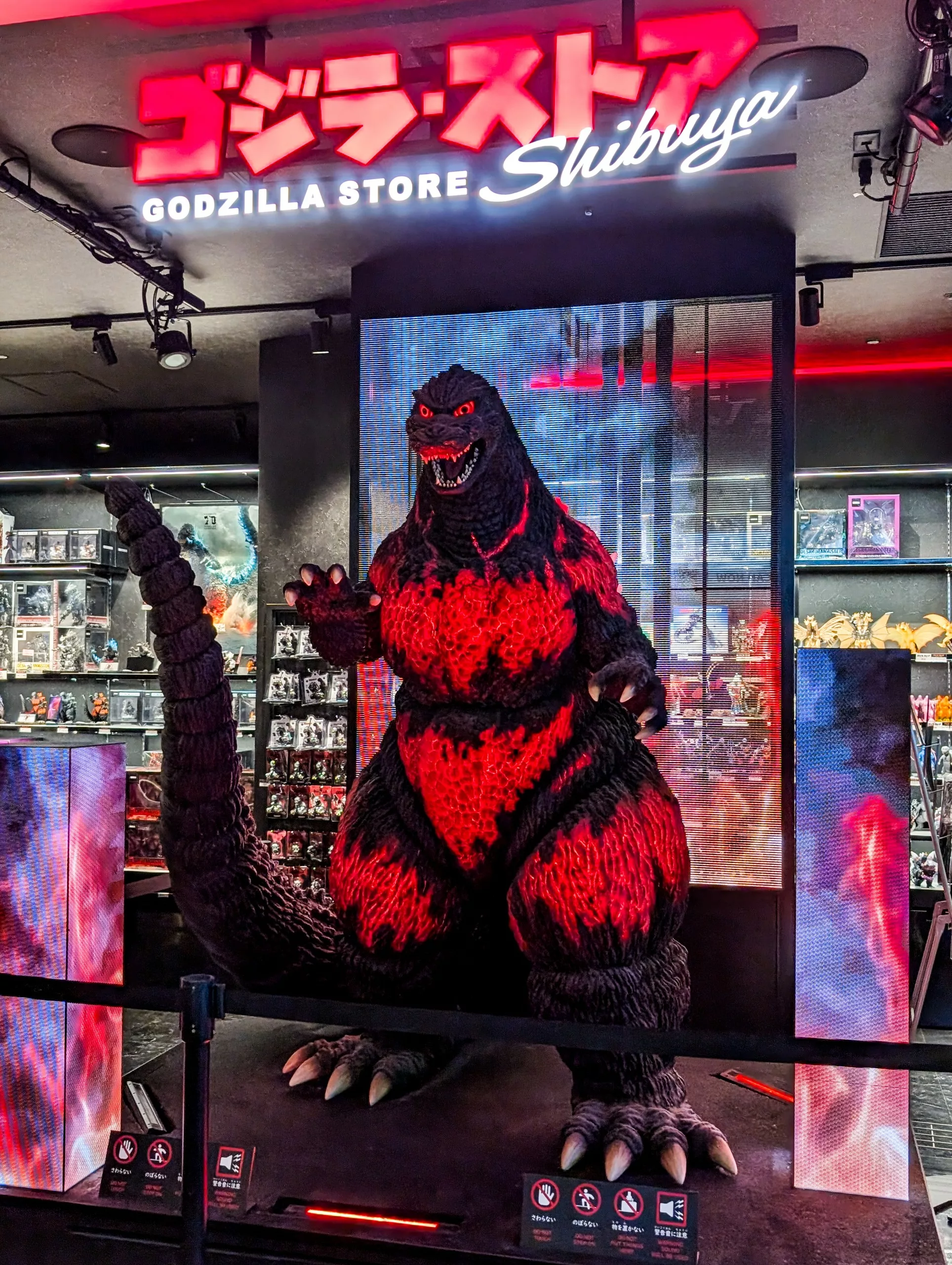 Une grande statue de Godzilla aux accents rougeoyants se dresse à l'intérieur du Godzilla Store Shibuya, un lieu incontournable pour les fans et un must sur la liste des choses à faire à Tokyo