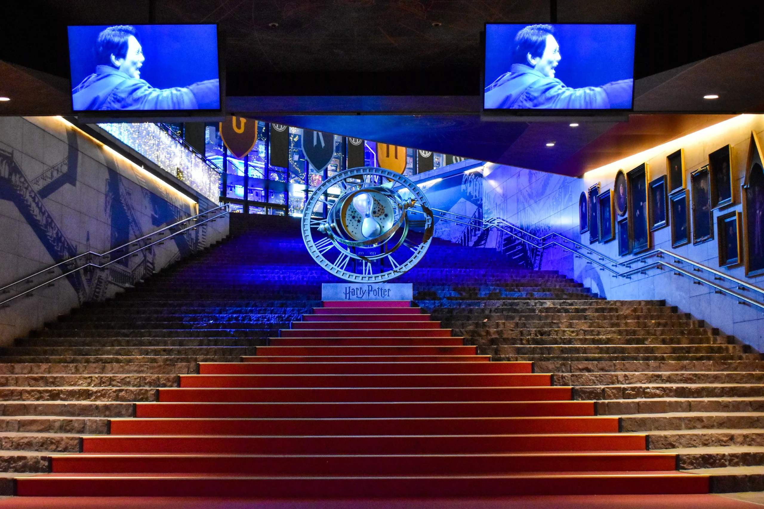 Un large escalier avec un tapis rouge mène à un grand accessoire circulaire au sommet, entouré d'un décor sur le thème d'Harry Potter - une inspiration parfaite si vous vous demandez que faire à Tokyo en tant que fan du film.