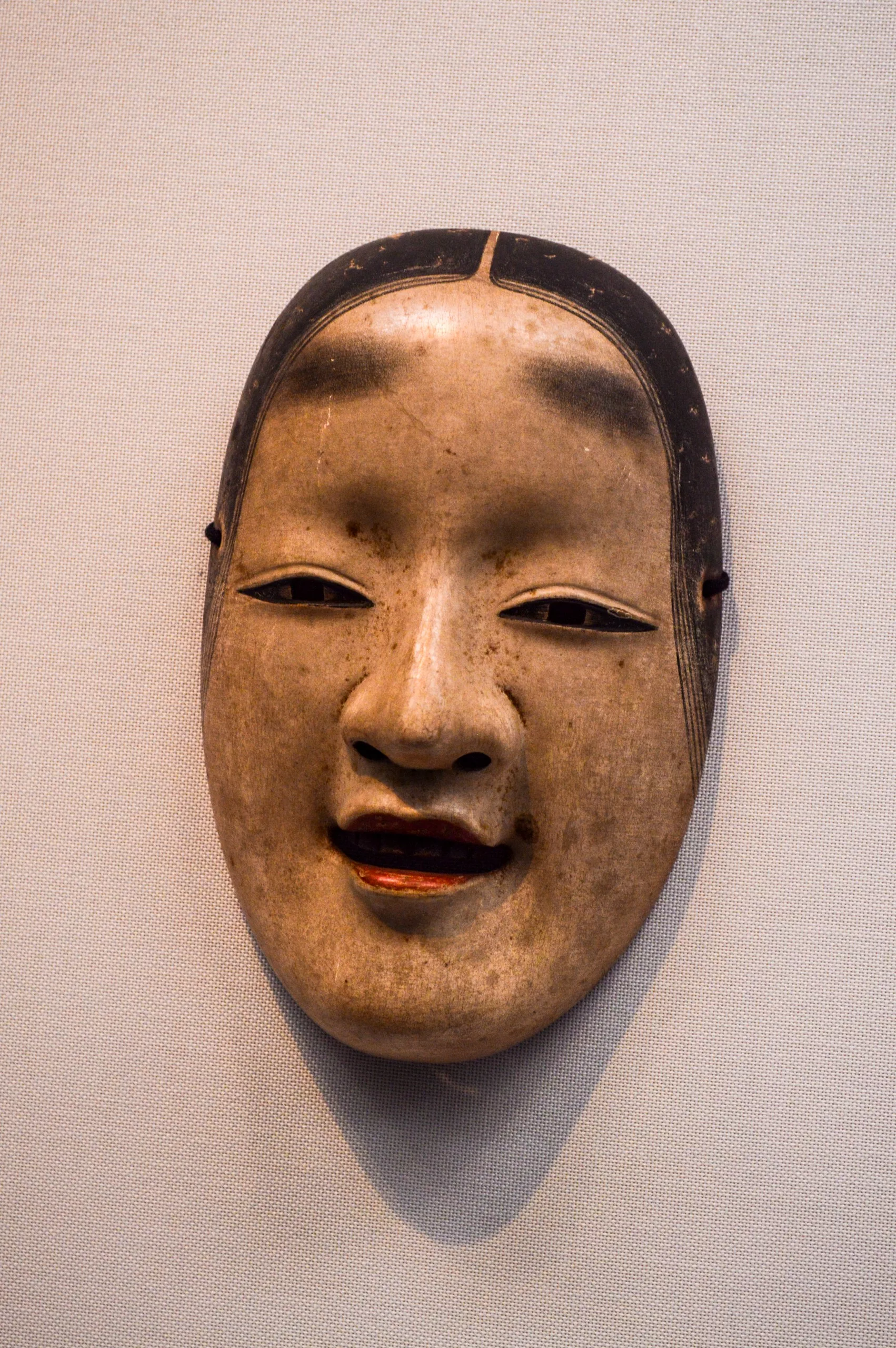Masque de théâtre nô traditionnel japonais à l'expression légèrement souriante et aux traits peints