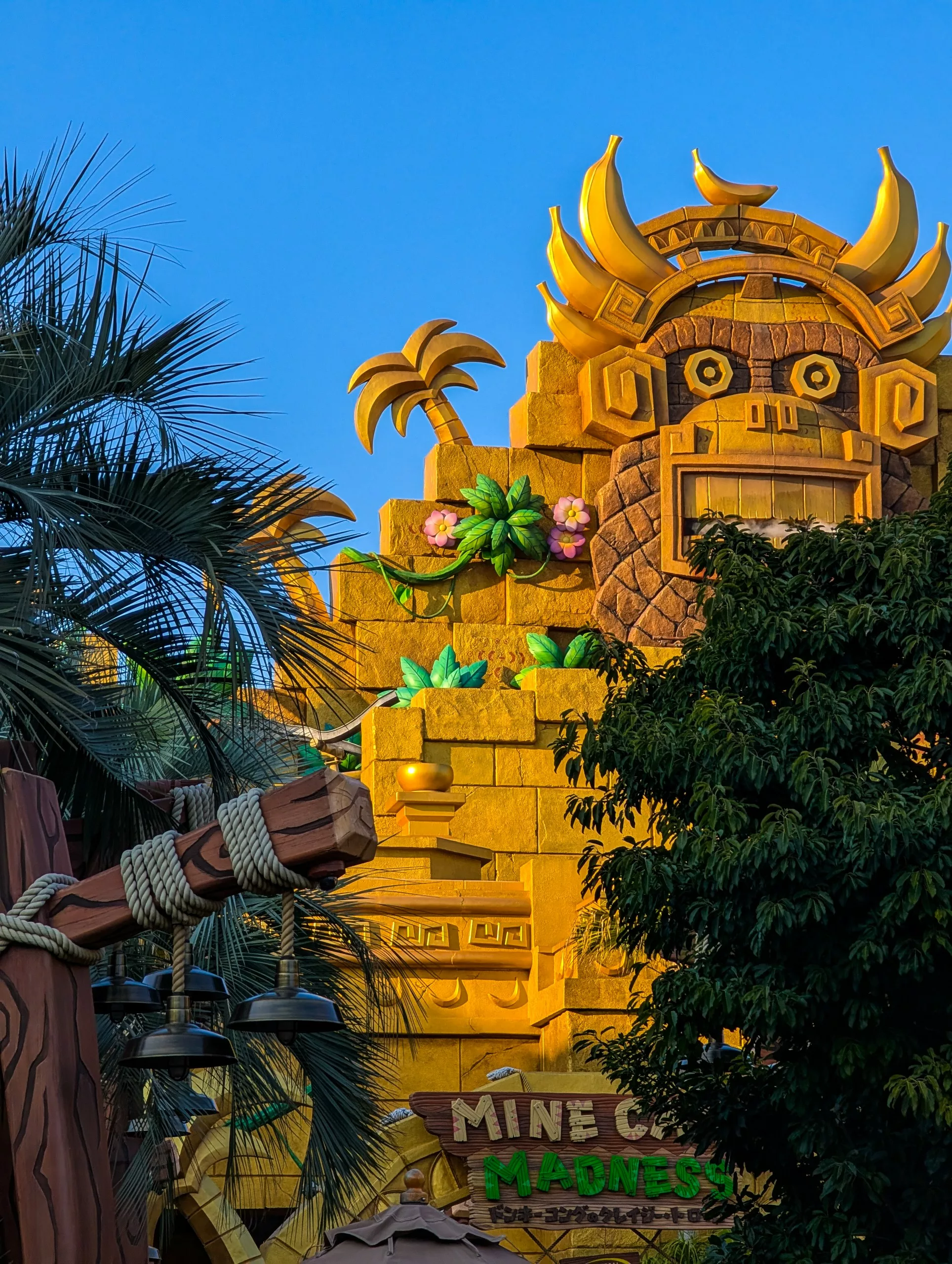 Un bâtiment jaune vif avec une façade caricaturale en pierre, de grands yeux et des décorations en forme de palmier accueille les visiteurs 