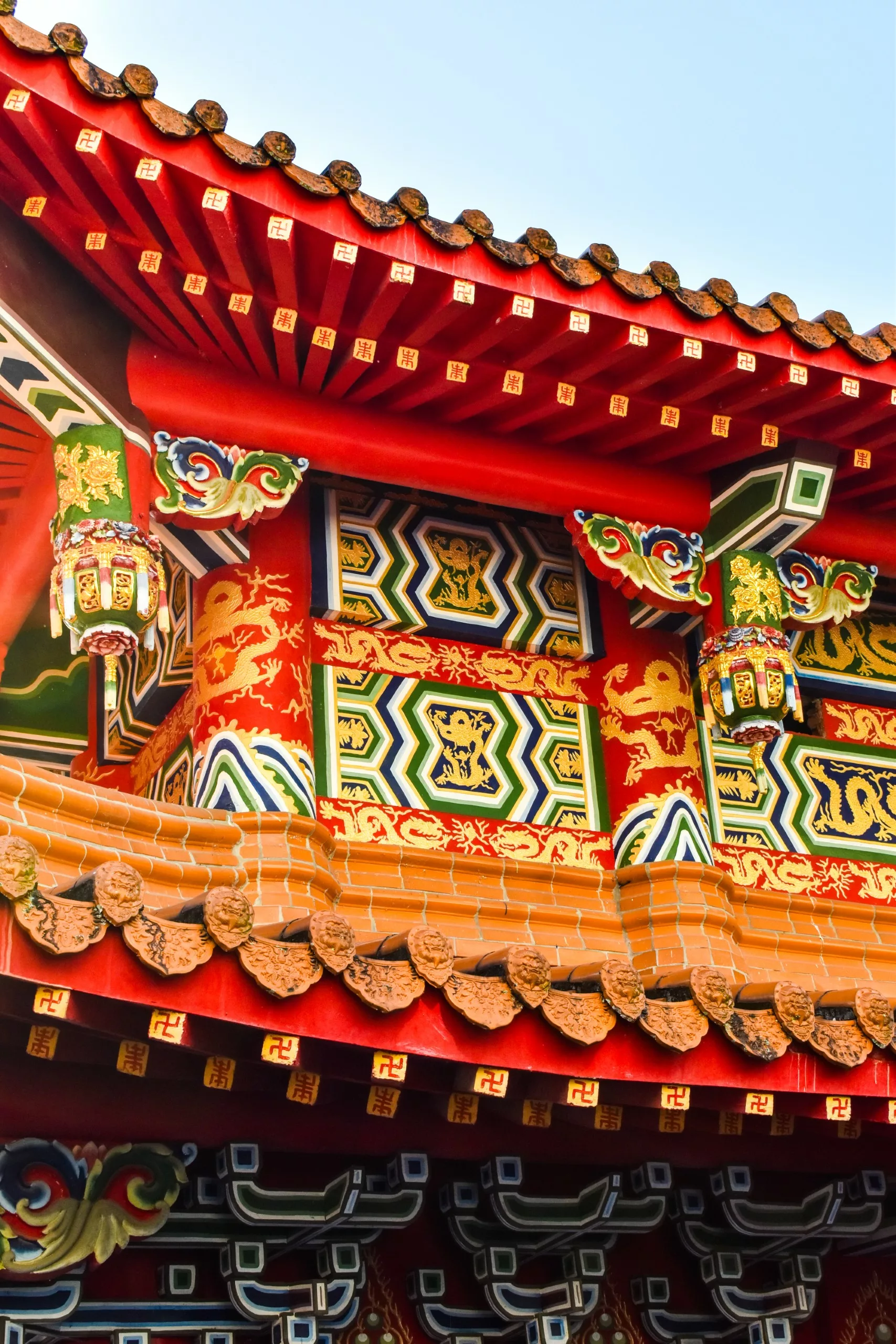 Gros plan sur le toit d'un bâtiment traditionnel d'Asie avec des motifs ornés et colorés, des motifs de dragons et des tuiles décoratives