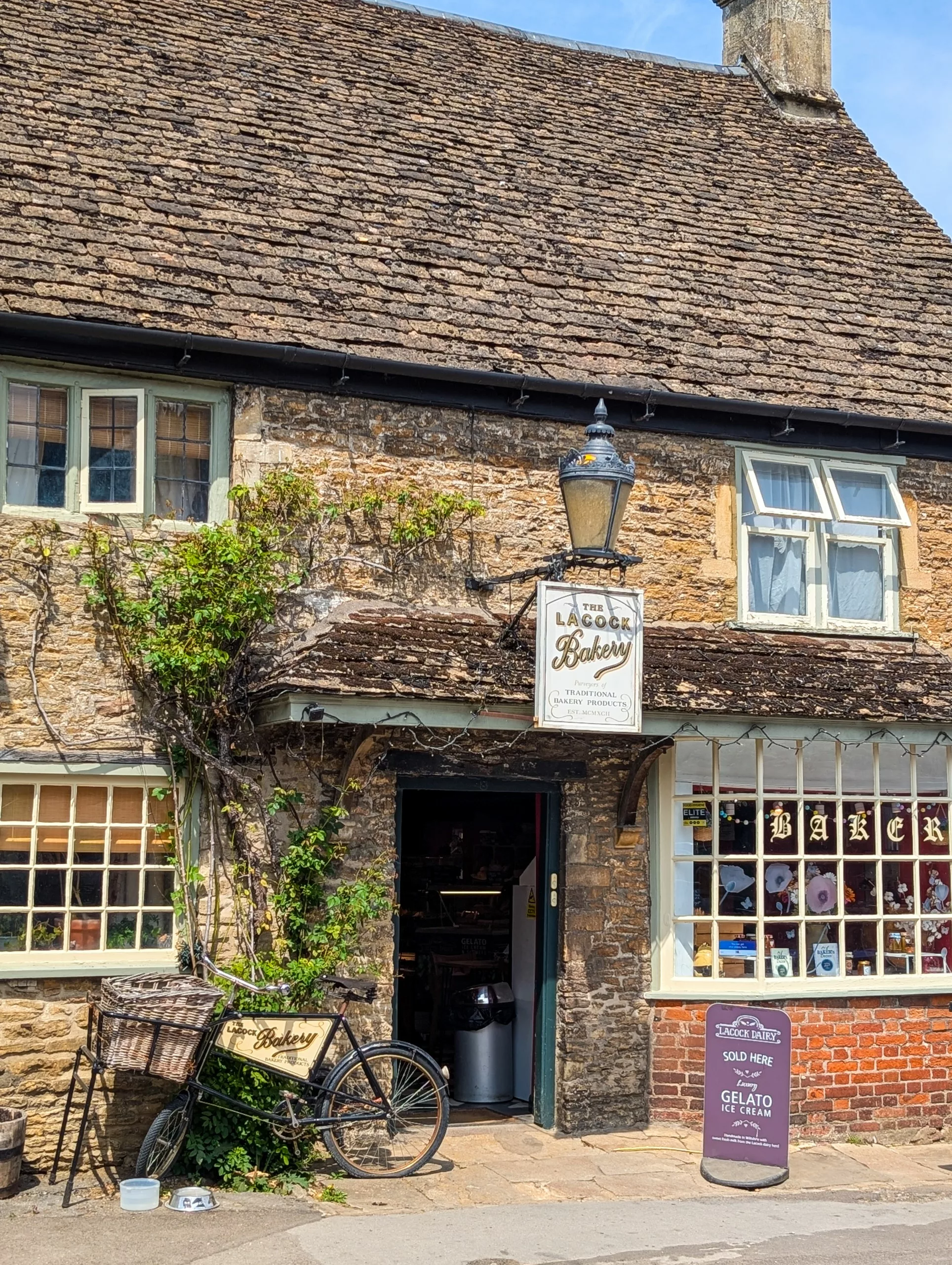 La devanture de la boulangerie Lacock, avec un vélo vintage garé devant et une enseigne annonçant des glaces.